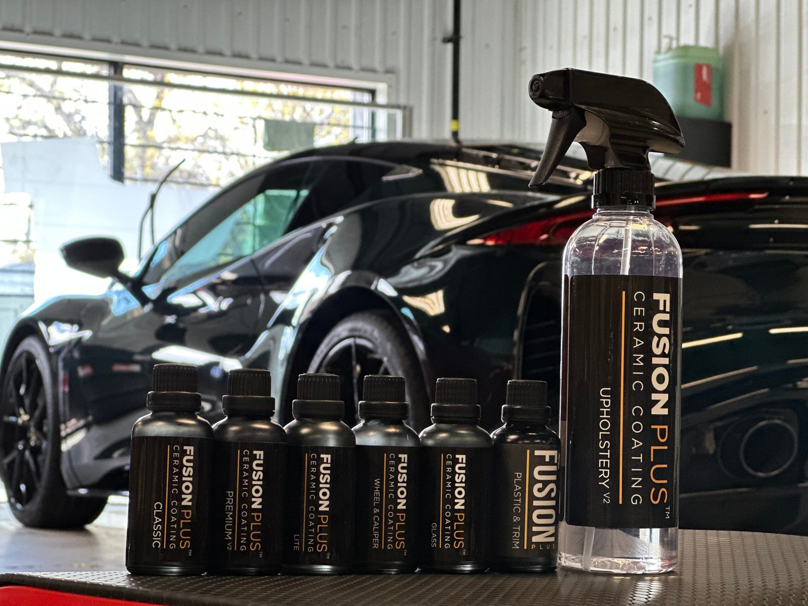 A lineup of professional XPEL Fusion Plus ceramic coating bottles and surface prep products in an Ottawa detailing shop.