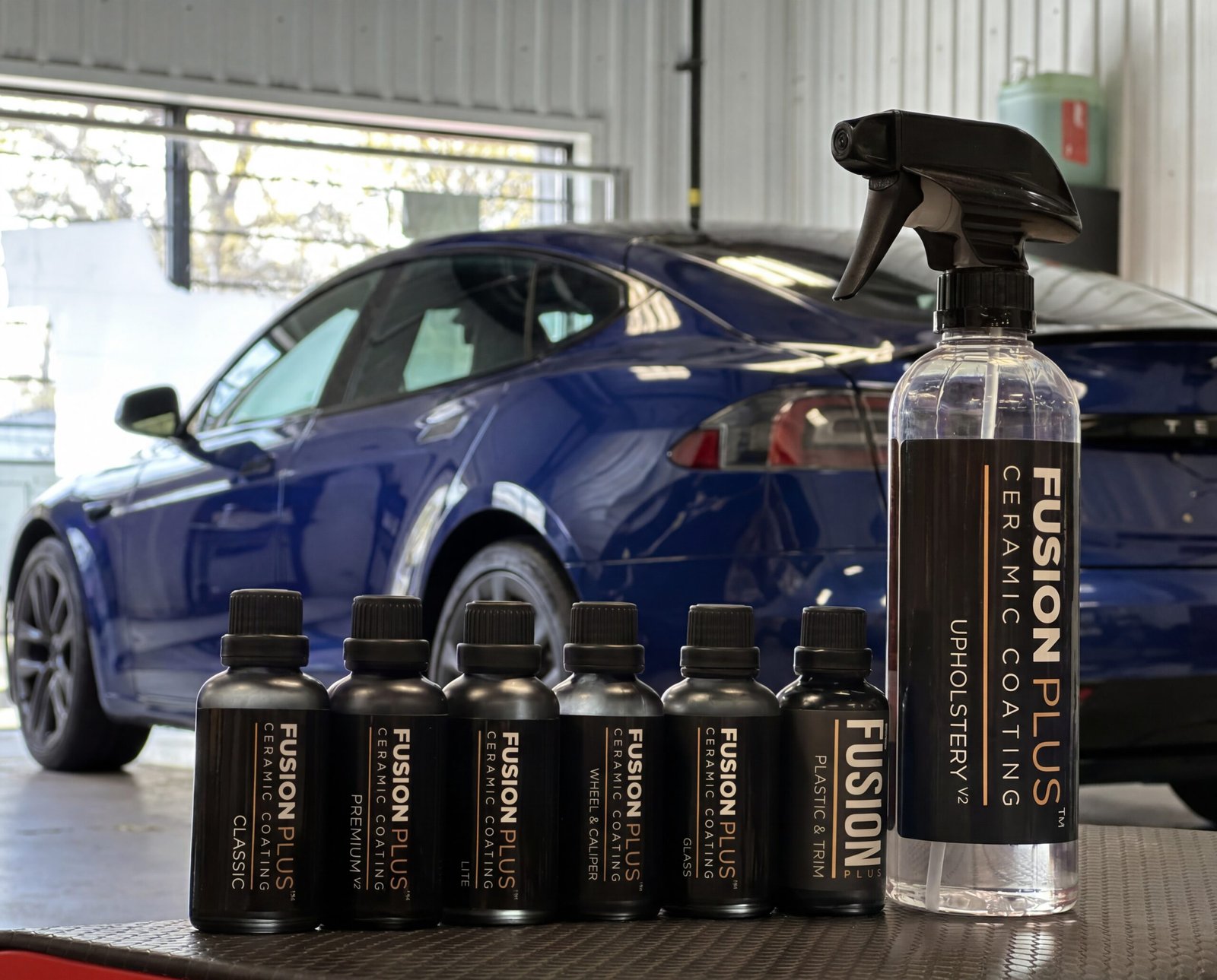 Applying a high-gloss ceramic coating to a Tesla body panel in an Ottawa detailing studio.